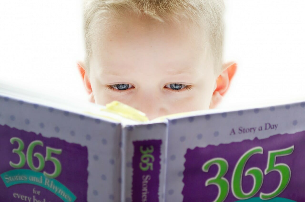 Child learning from a book titled 365