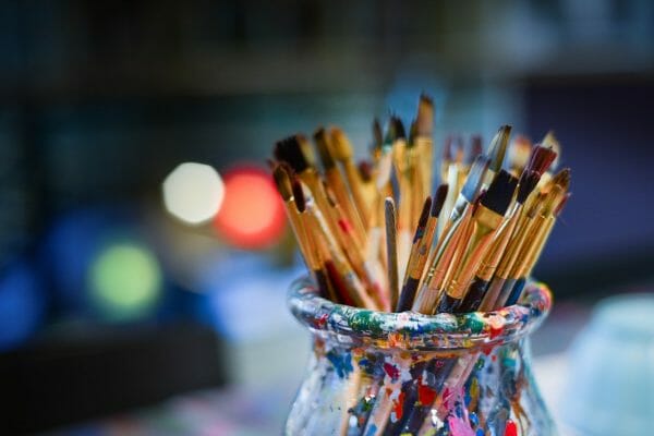 Picture of many paint brushes in a glass jar