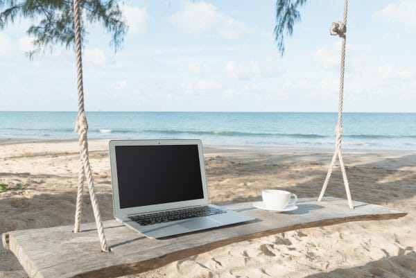 Lone laptop on a swing at the beach