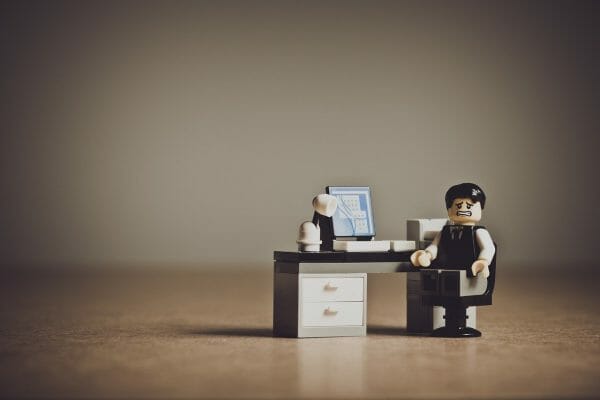 Lego business man looking stressed at desk